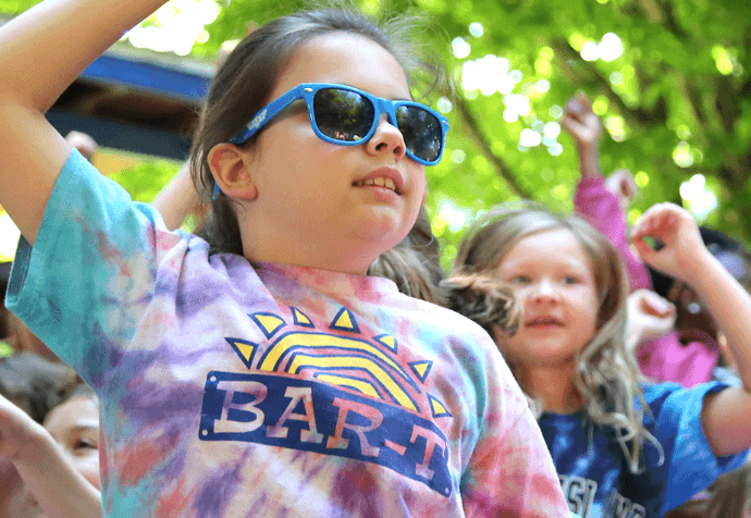 Young campers dancing and jumping with sunglasses on