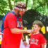 Counselor putting a microphone in front of a campers mouth while speaking on stage