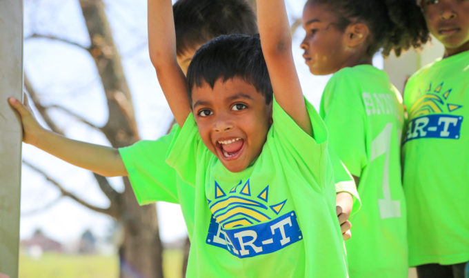 Young campers in bright green shirts on a playground