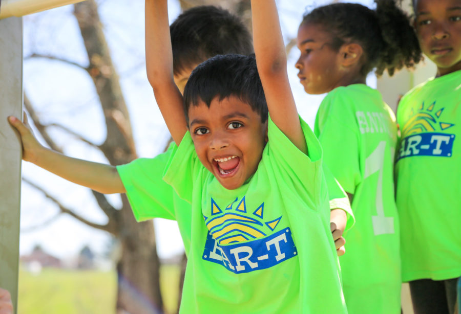 Young campers in bright green shirts on a playground