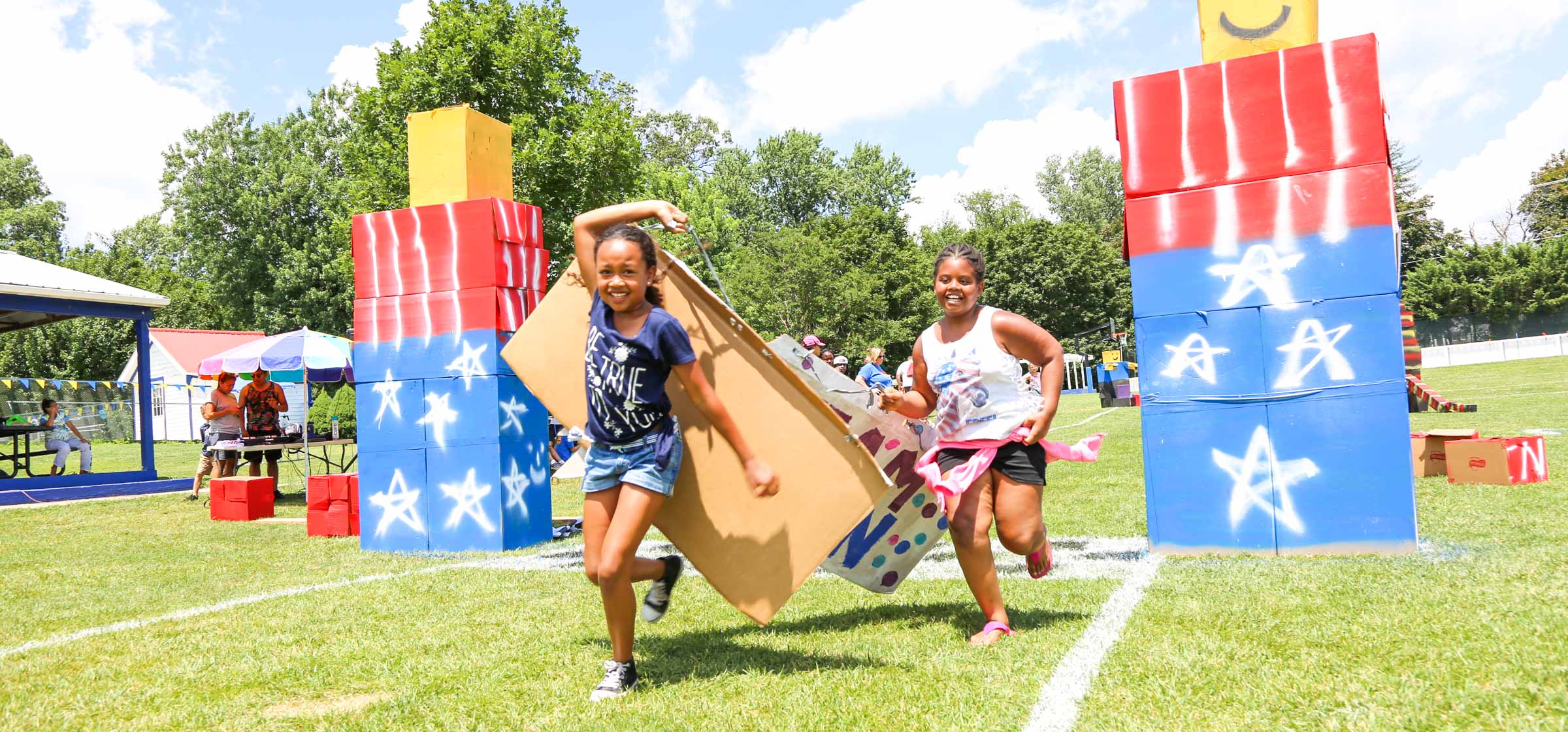 Campers running with cardboard behind them