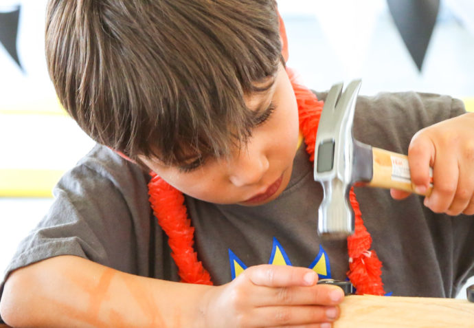 Camper hammering and building a wooden toy car