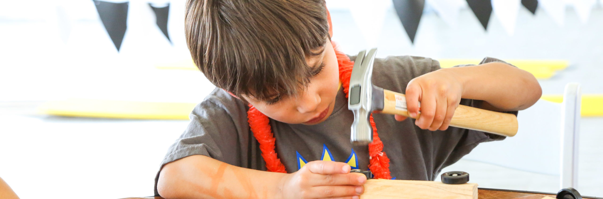 Camper hammering and building a wooden toy car