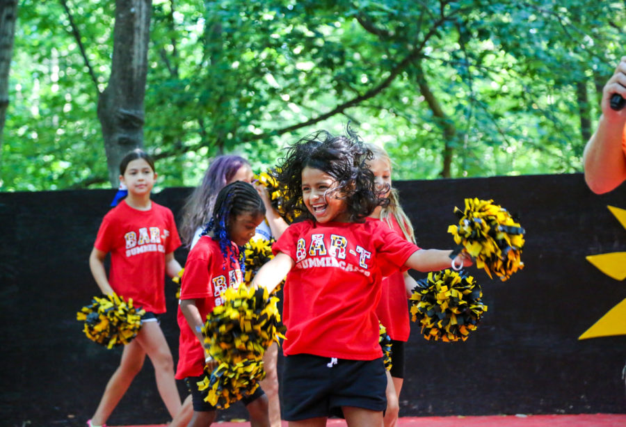 Campers practicing cheerleading on stage