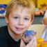 Boy camper holding up the cupcake he decorated for a photo