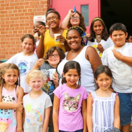 Group of kids with a counselor eating ice cream taking a group photo having fun
