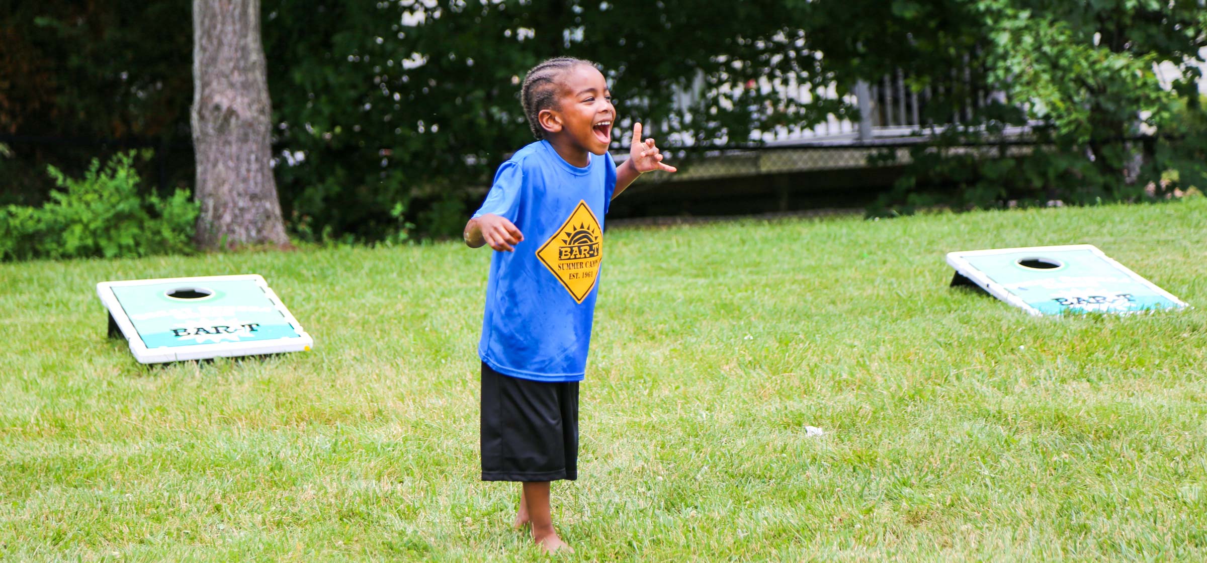 Young camper yelling in excitement in a field