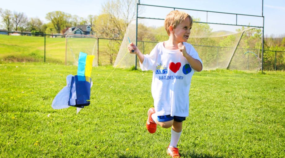 Camper running with a kite behind him