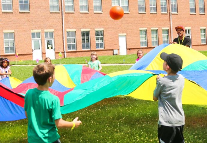 Campers playing a parachute game on the grass