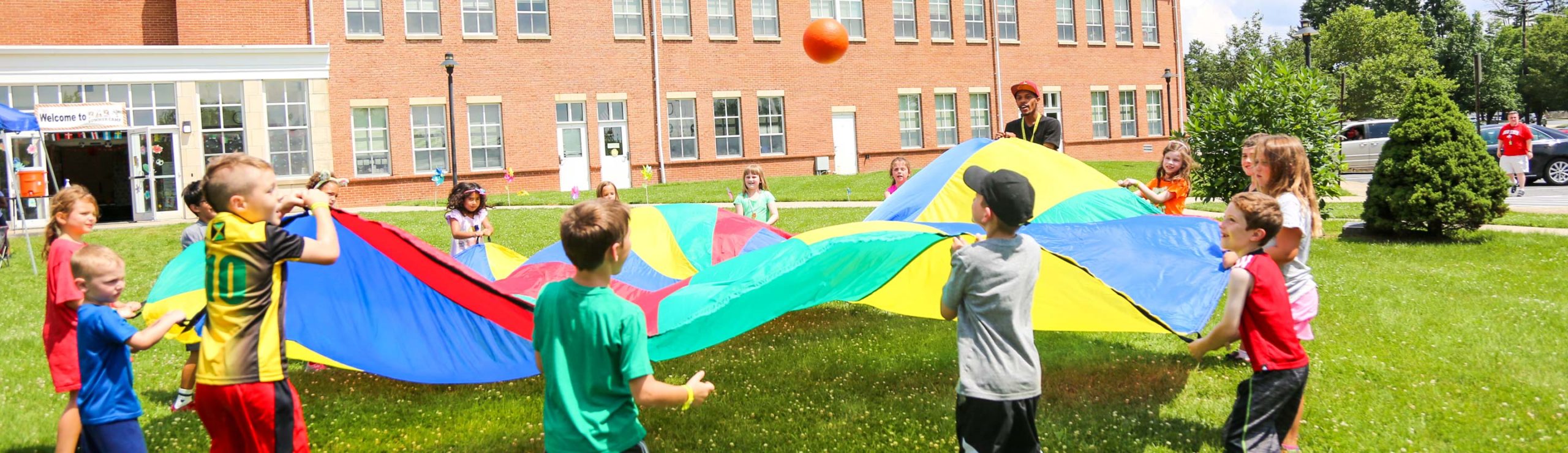 Campers playing a parachute game on the grass