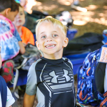 Young boy camper smiling big for the camera