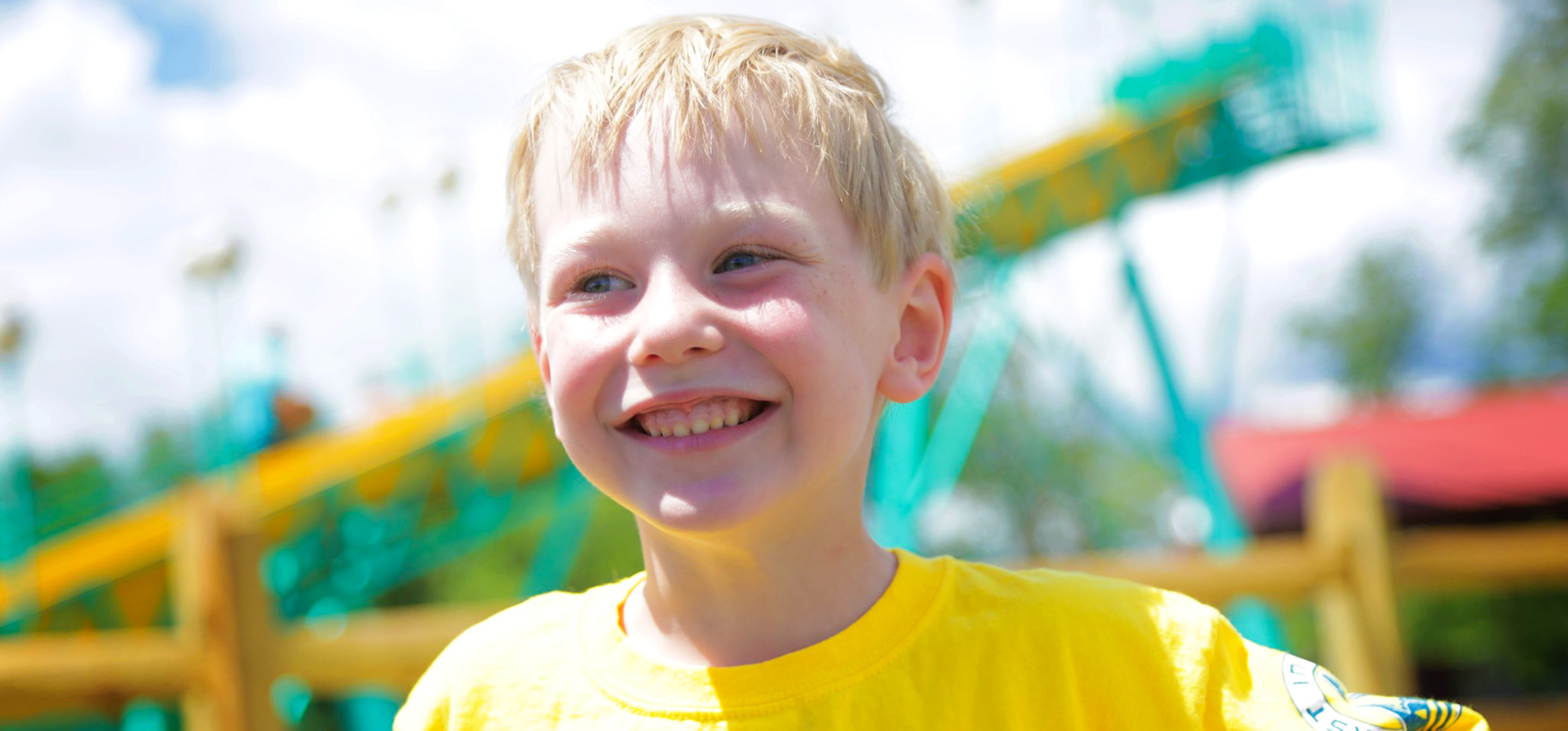 Young boy camper with yellow shirt smiling