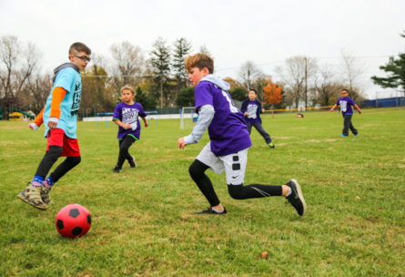 Campers playing soccer outside