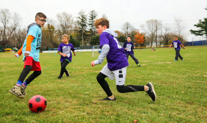 Campers playing soccer outside