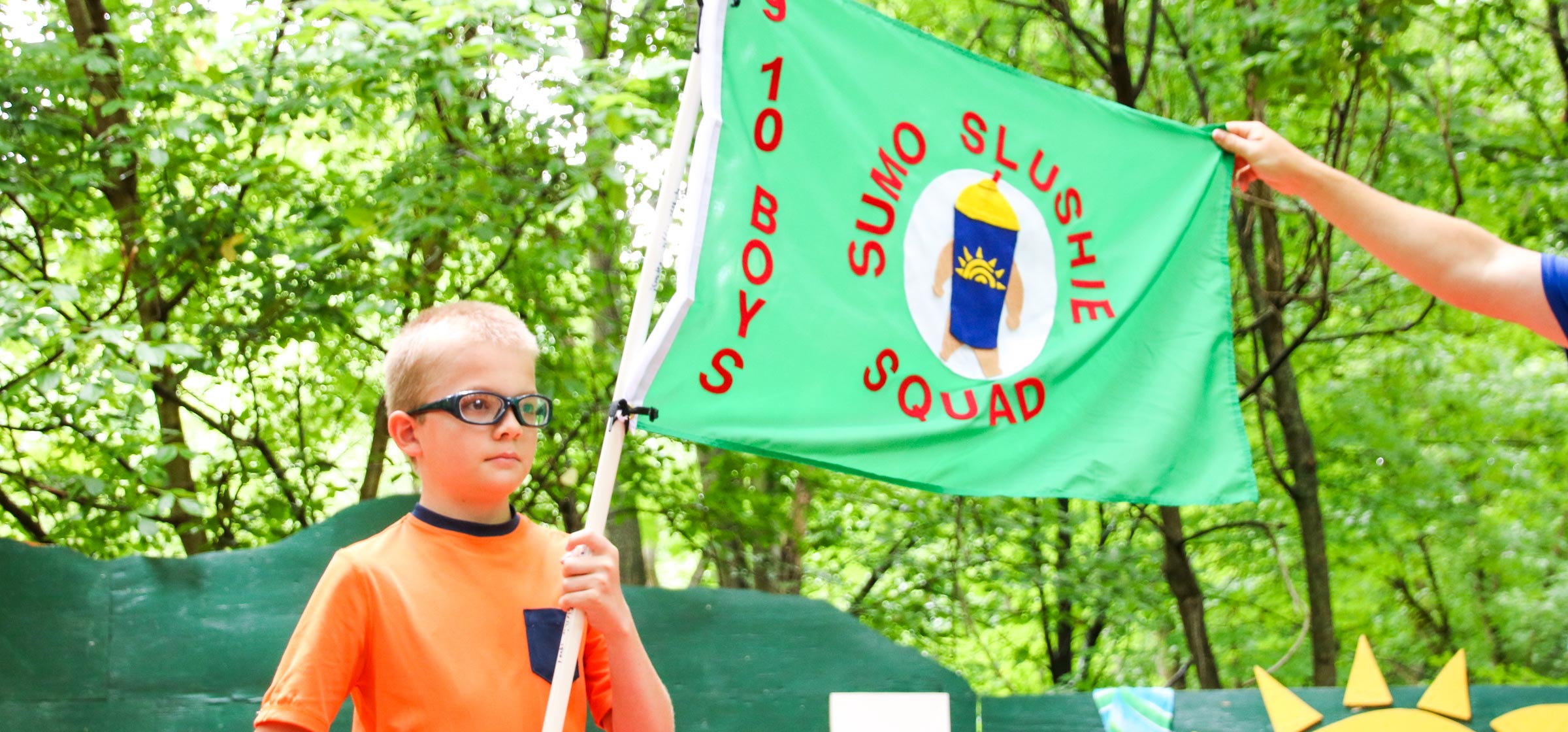 Camper holding a flag with Sumo Slime Squad written on it