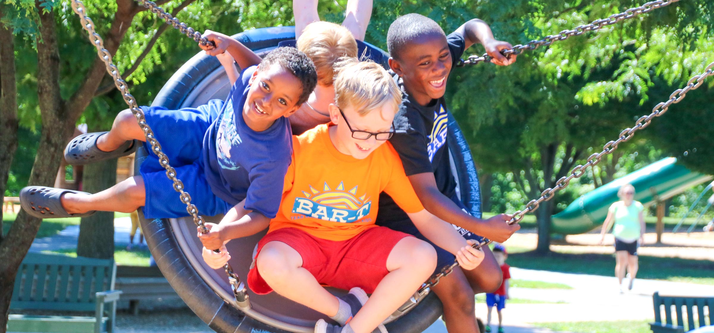 Four friends on a tire swing having fun