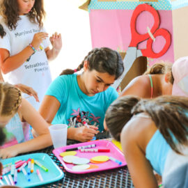 Group of girls doing arts and crafts at a picnic table