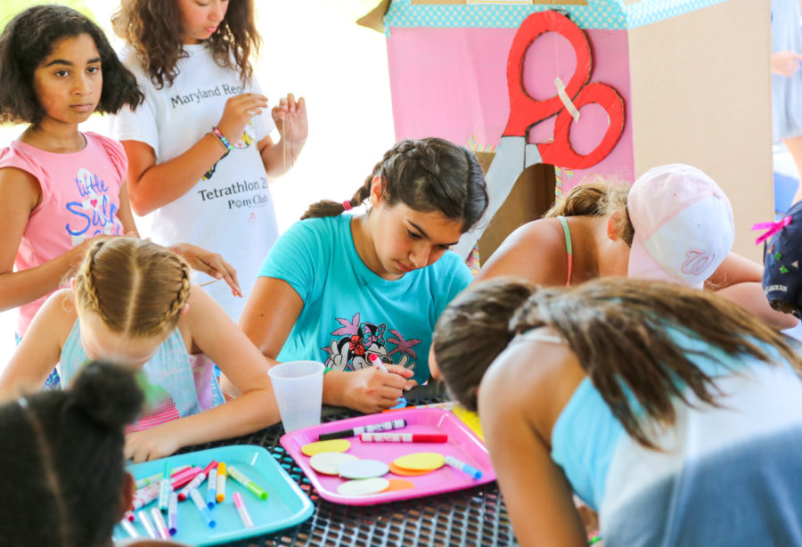 Group of girls doing arts and crafts at a picnic table