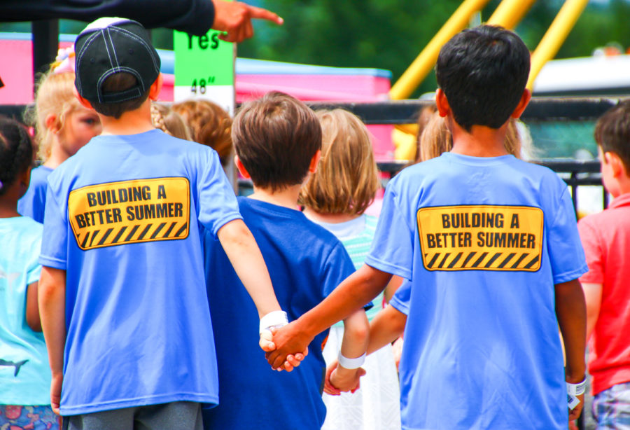 Two friends holding hands with Bar-T shirts on