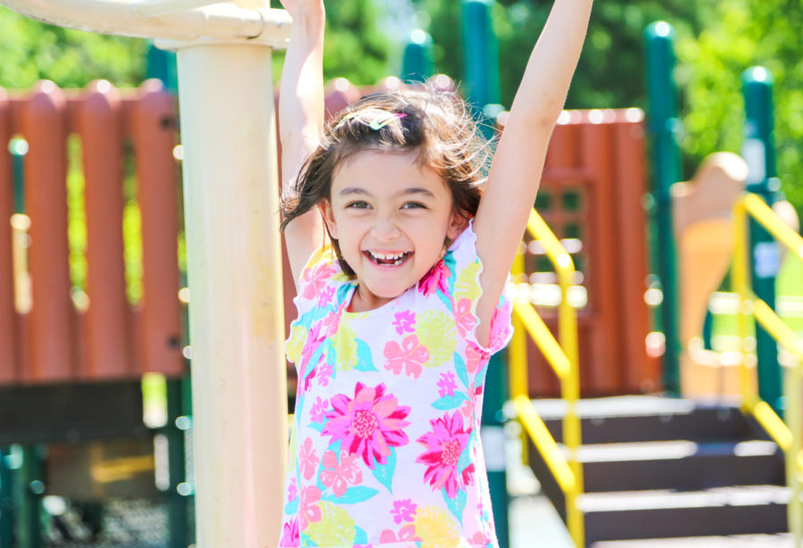 Young girl smiling while on the monkey bars