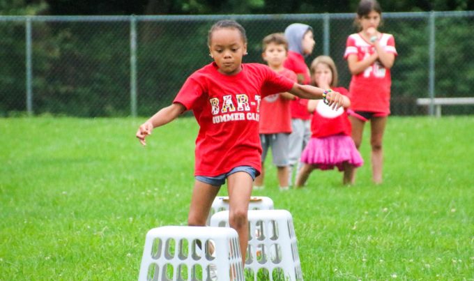 Camper running in the grass for a relay race