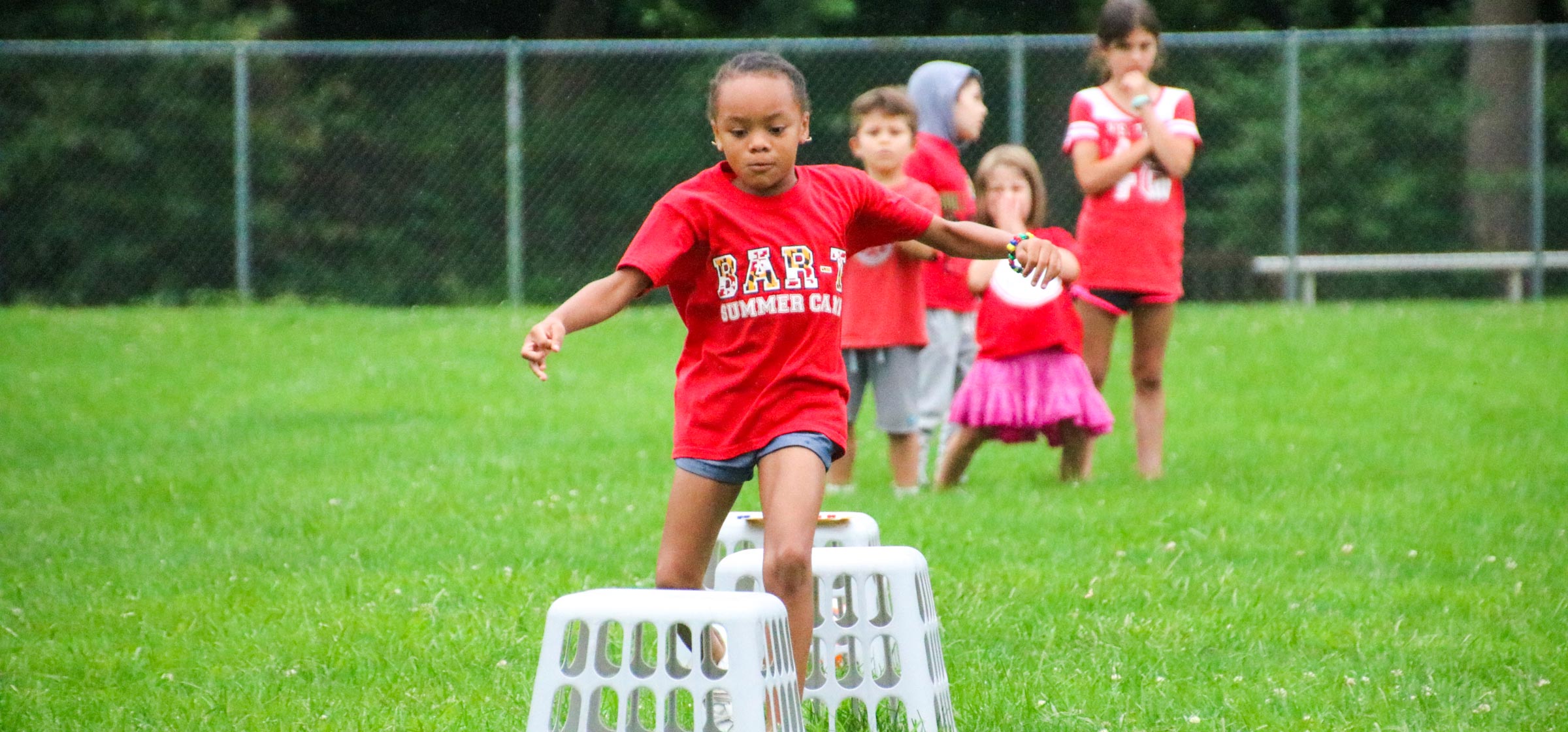 Camper running in the grass for a relay race