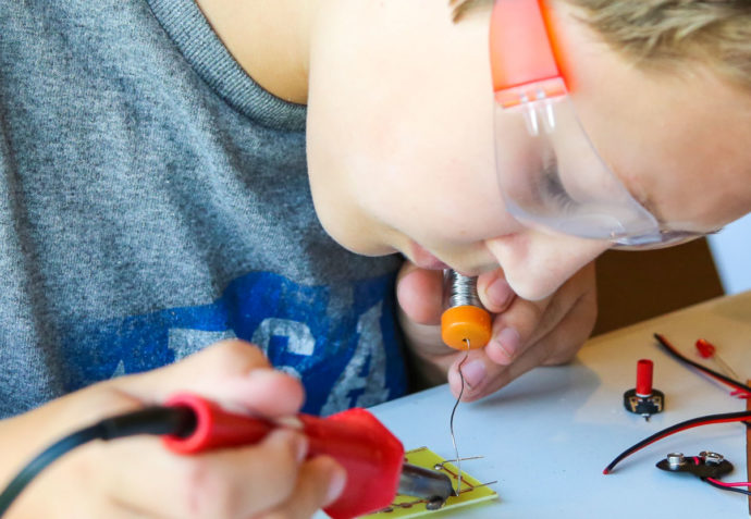 boy soldering something together